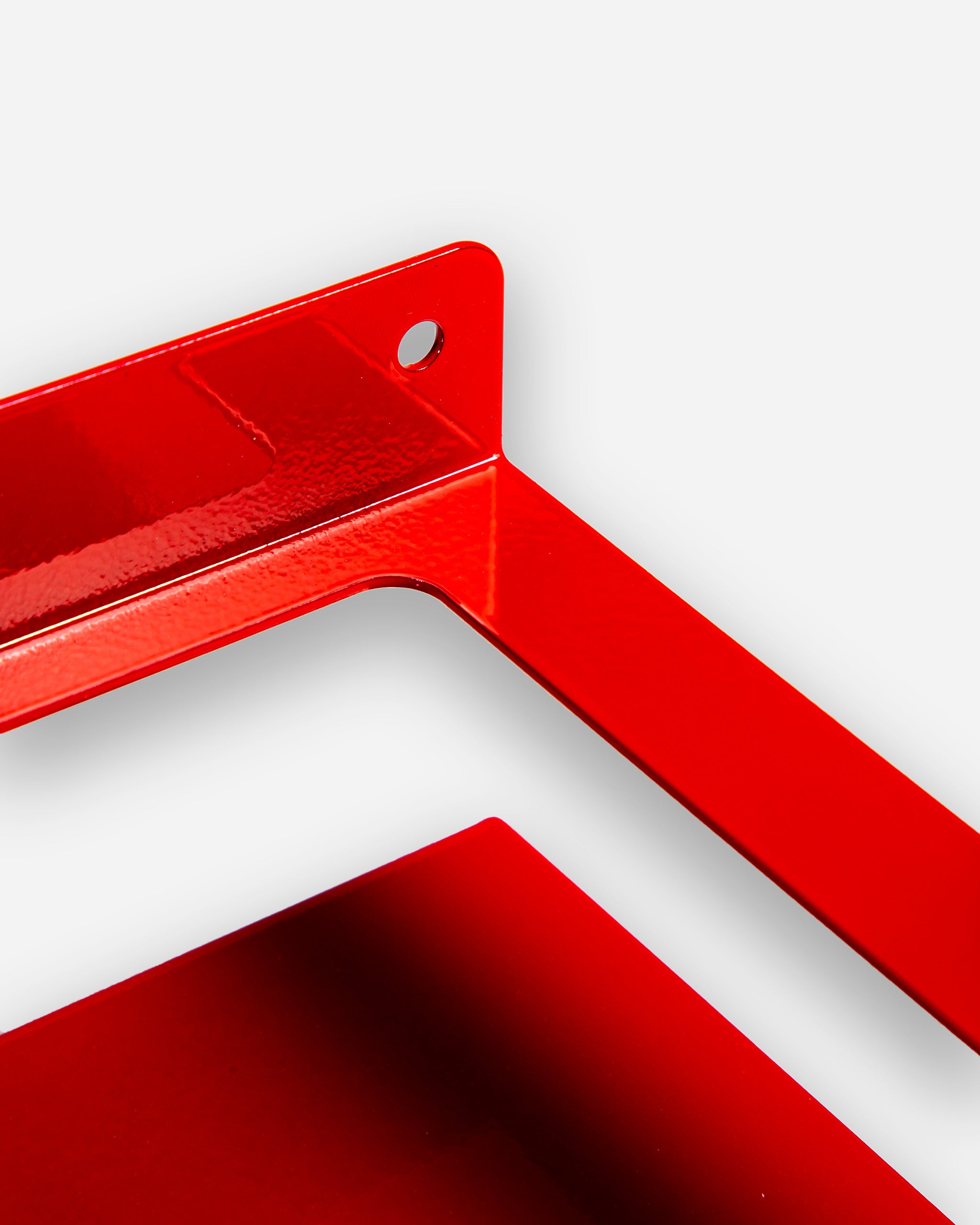 Close-up of a red, glossy Adam's 1 Gallon Holder with metal construction and a mounting hole at the top.