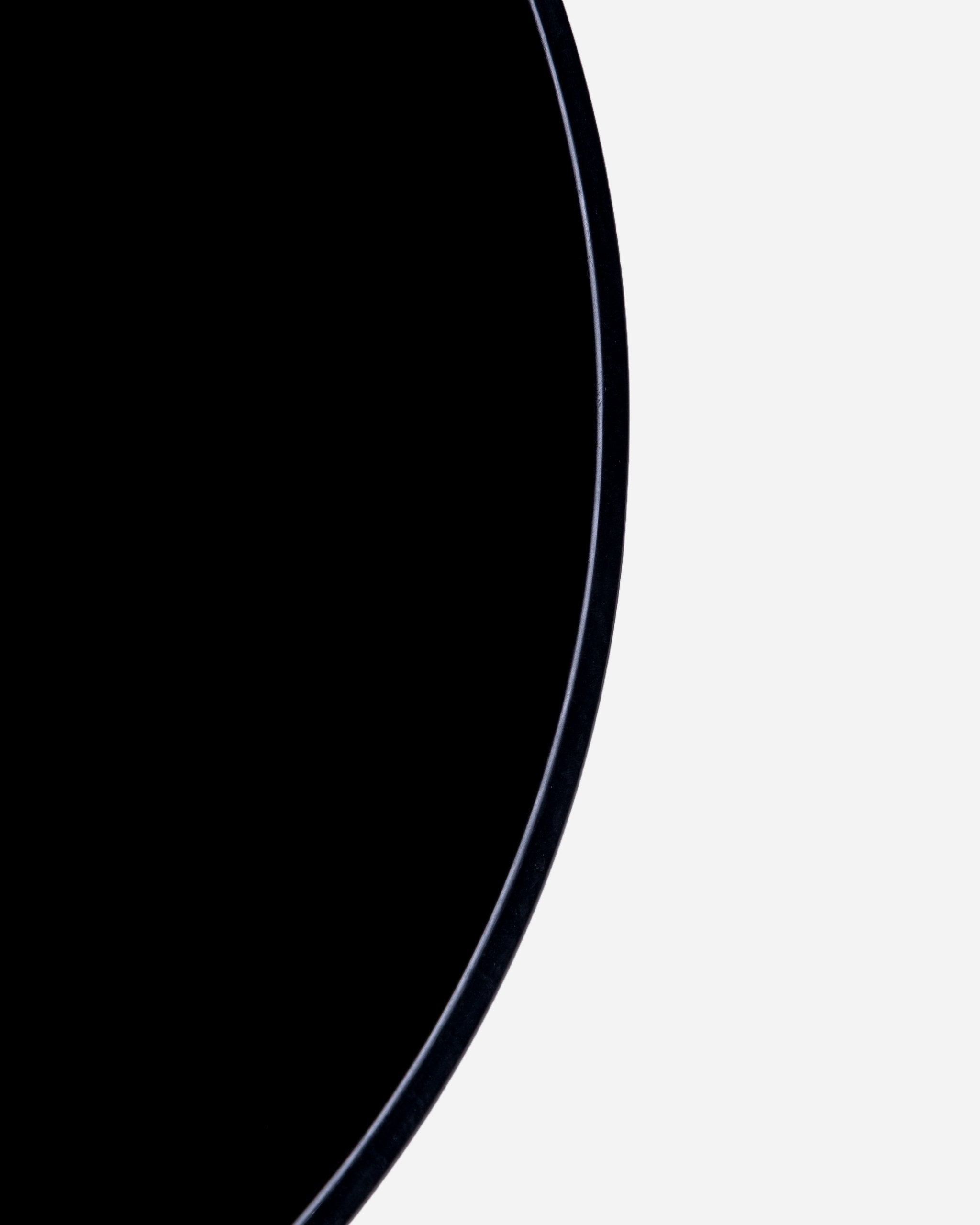 Alt text: Close-up of the top rim of Adam's Mystery Bucket, primarily showing a sleek black edge against a stark black background.