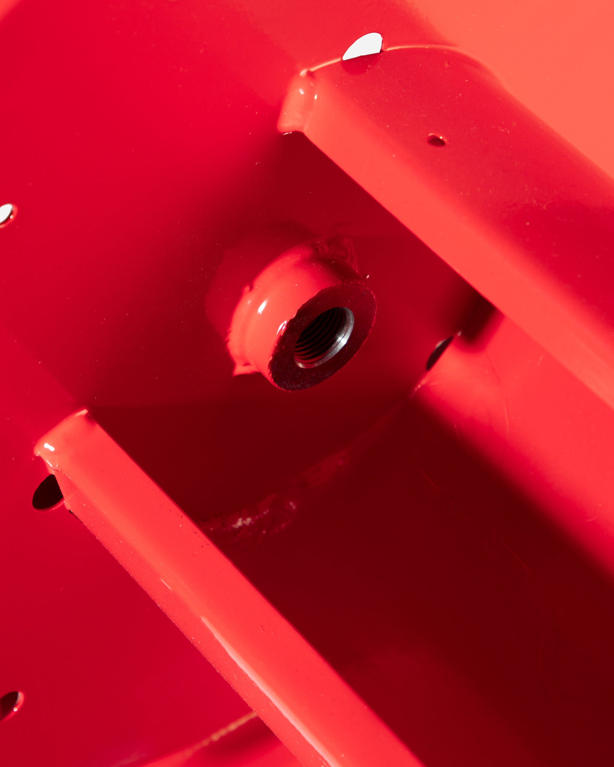 Close-up view of a red garden hose reel connector showing detail of the threading and structure, part of Adam's 100' Premium Hose Reel.