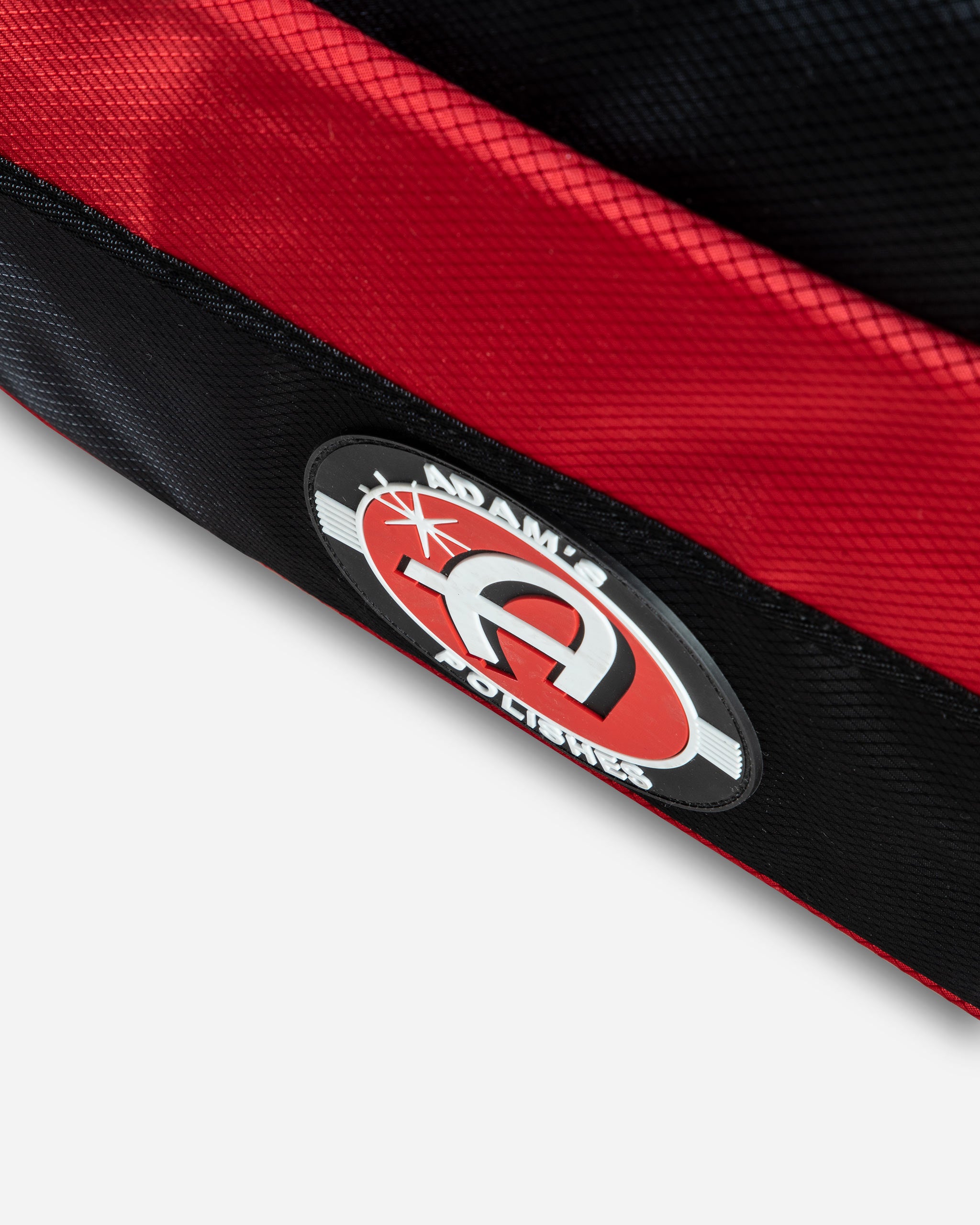 Close-up of Adam's Polishes Random Mystery Trunk Organizer V2 featuring the brand logo on a red and black fabric.