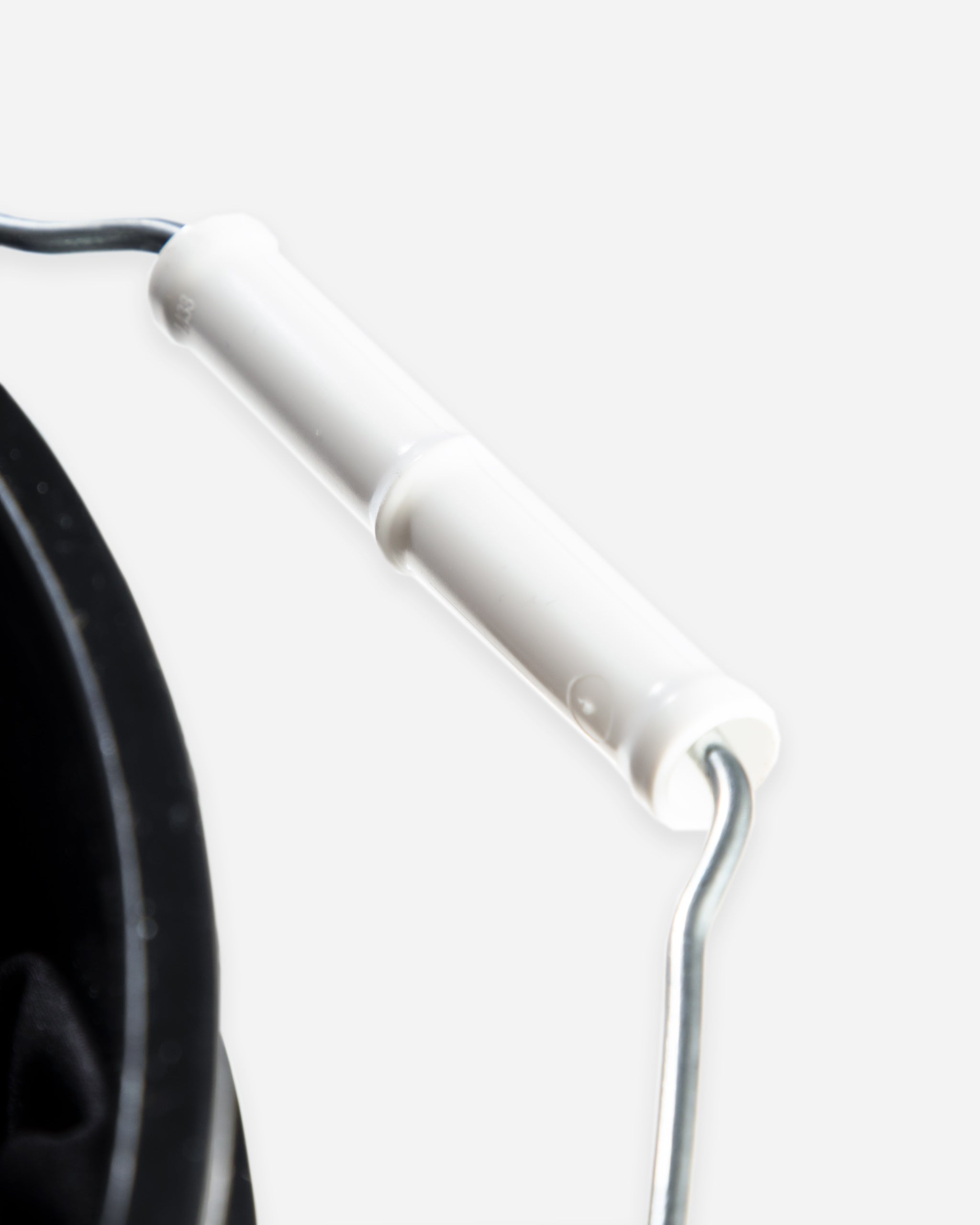 Close-up of a white handle of a bucket, focusing on the details of the grip and curvature.