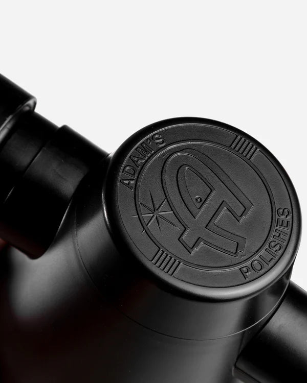 Close-up of Adam's Mystery Handheld Mini Air Cannon showing detailed embossed logo on a black surface.