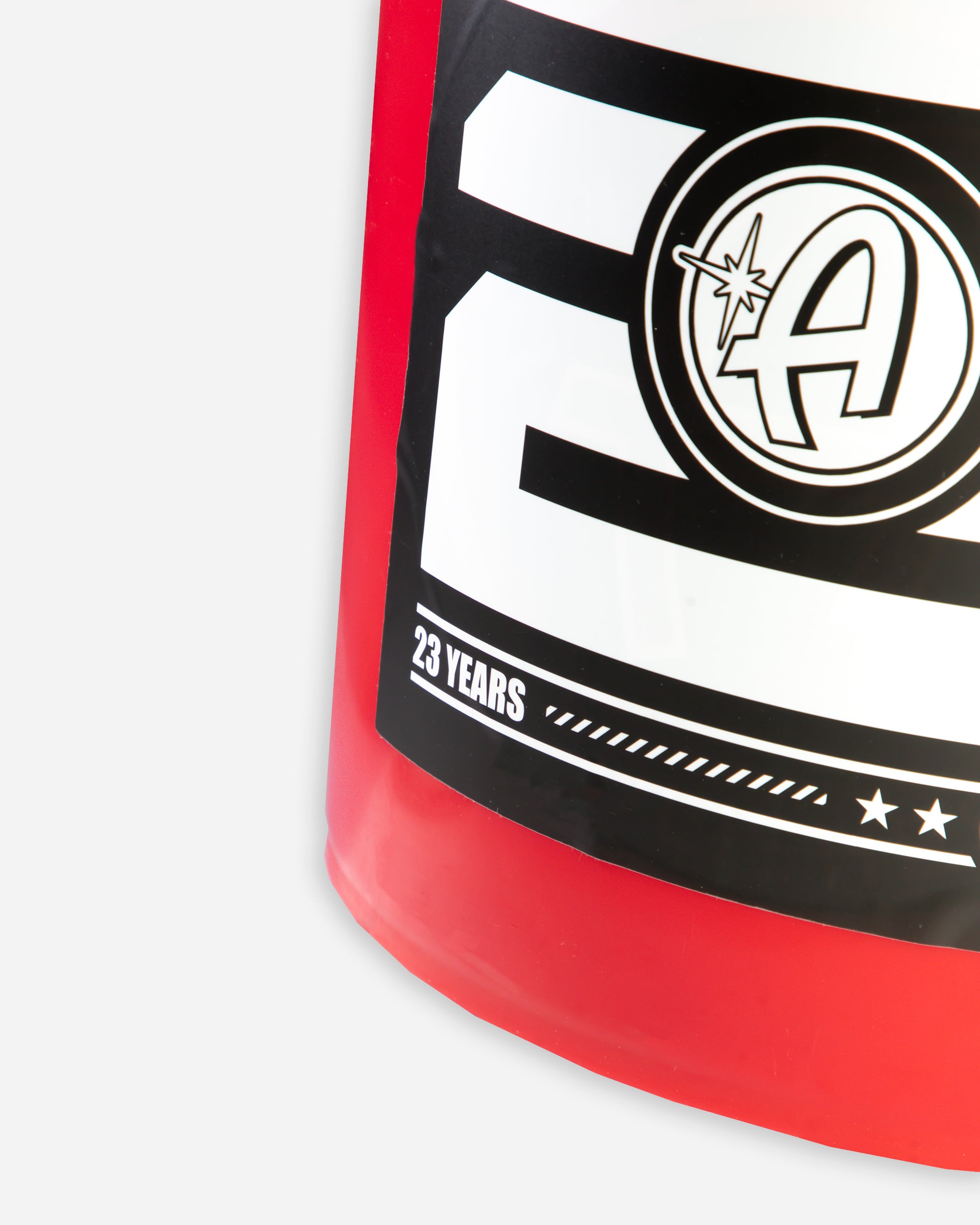 Close-up of Adam's Mystery Bucket in red, showing part of the product label featuring the Adam's logo and text marking "23 Years" in a black and white design.