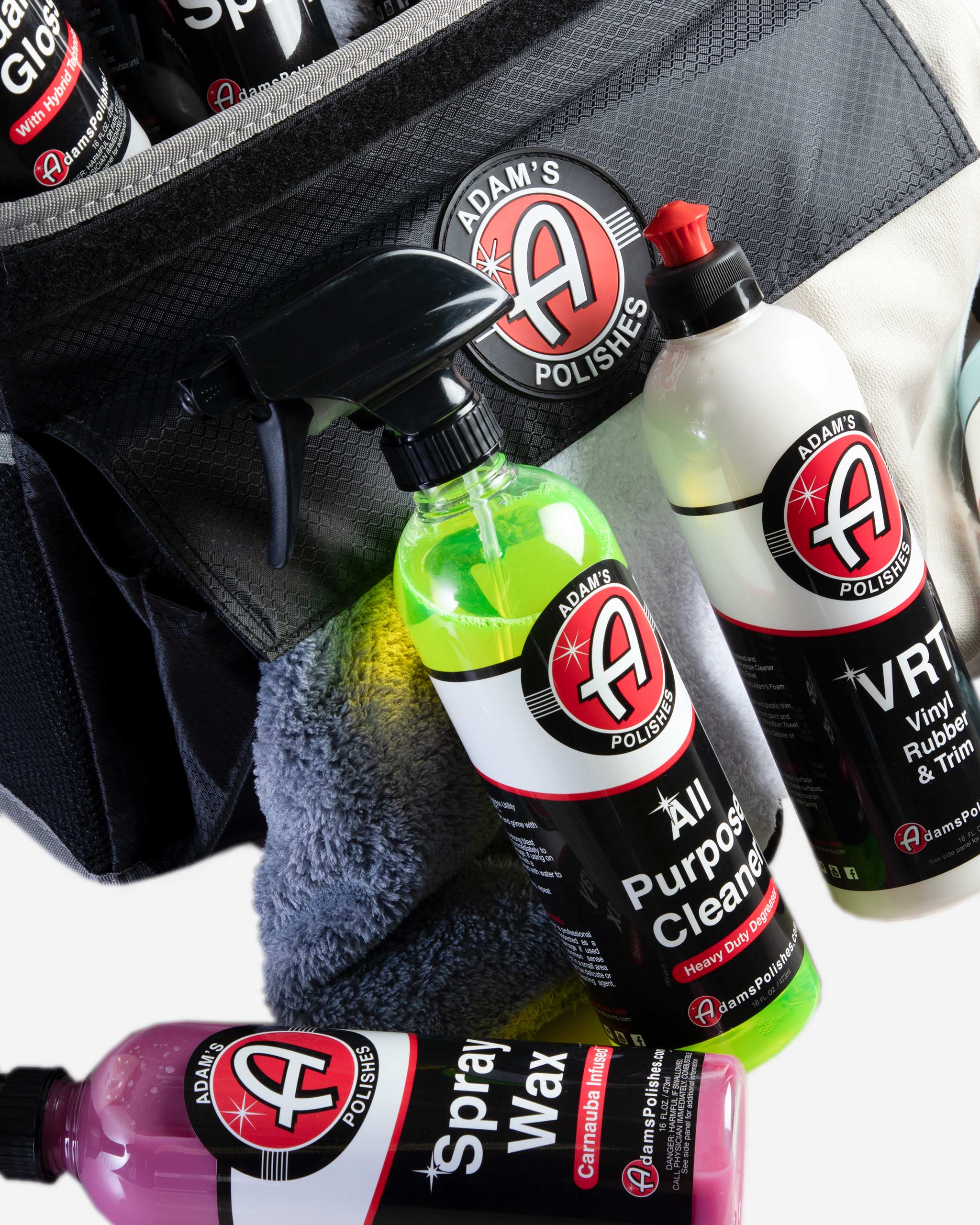 Alt text: "Adam's Polishes trunk organizer containing car care products, including bottles of spray wax, all-purpose cleaner, and microfiber towels, prominently displaying the brand's logos."