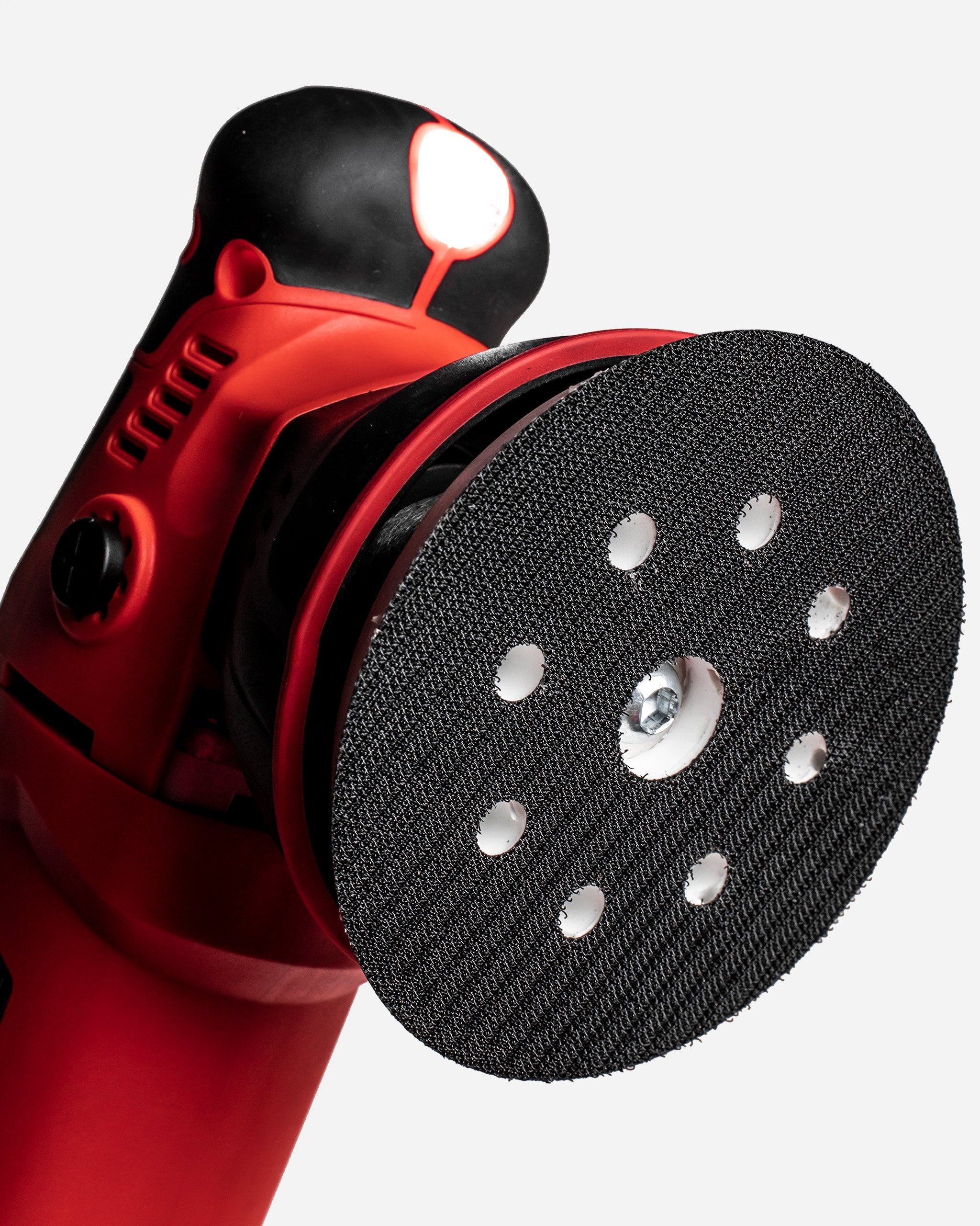 Close-up view of Adam's $299.99 SK Pro 15mm Polisher, featuring a red body, black grip, and a textured black polishing pad.