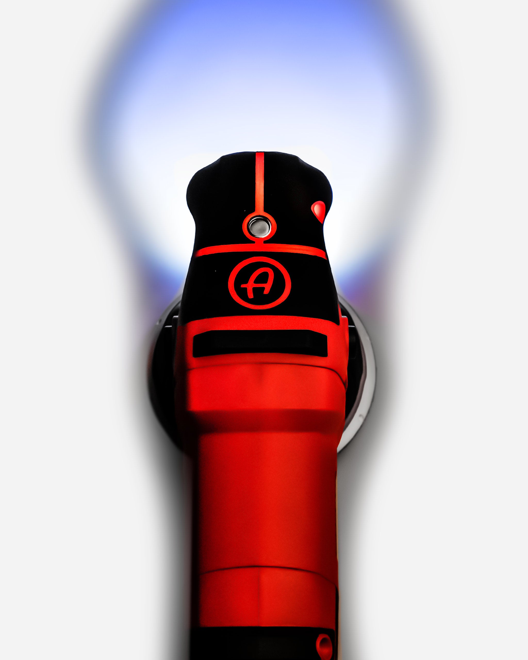 Alt text: Close-up view of Adam's SK Pro 15mm Polisher in red and black color scheme, with a distinctive logo on the head, set against a dynamic blurred background.